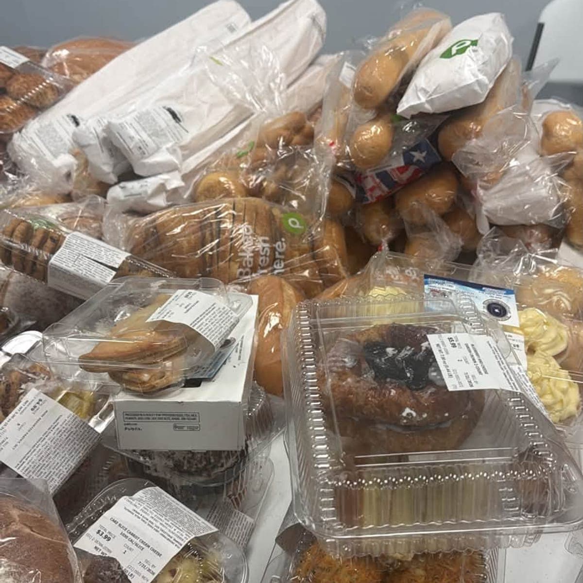 Mesa cubierta de panes y postres de panadería donados para el Food Drive