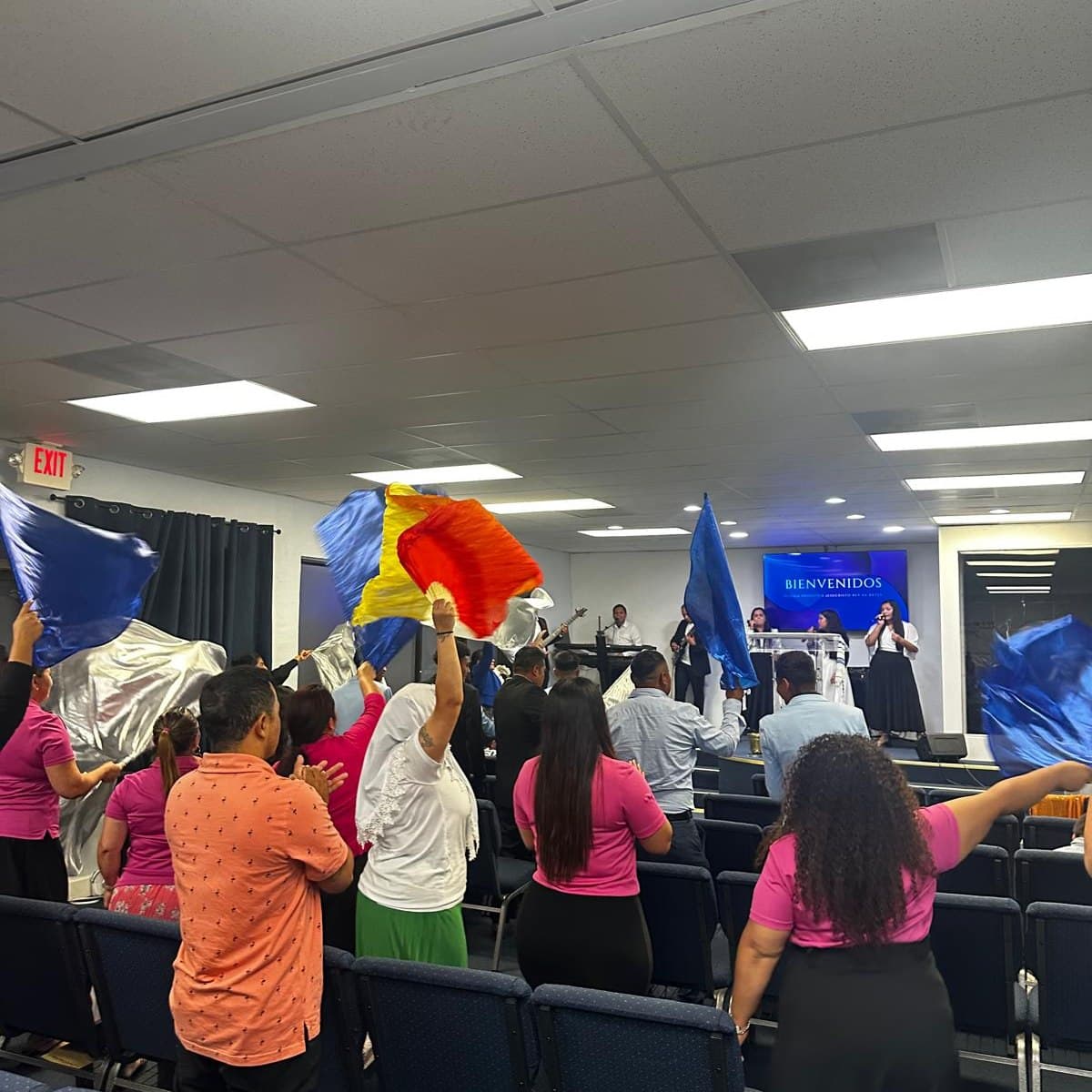 Congregación adorando con banderas de colores