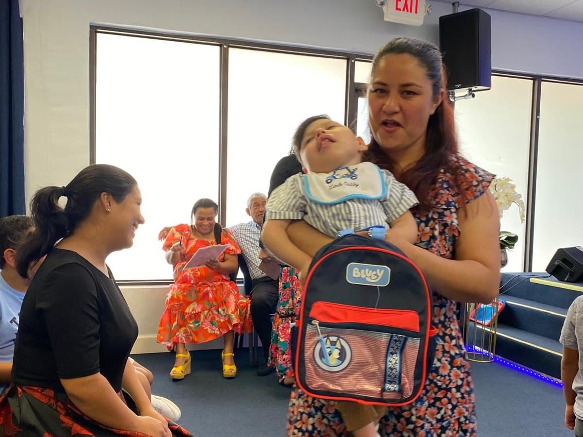 Madre sonriendo con su bebé en un evento de la iglesia